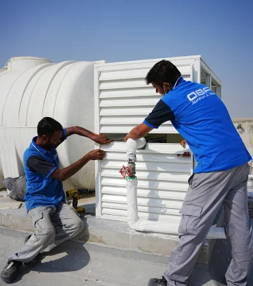 Aluminium louvers in Dubai being installed by technicians on a building rooftop.