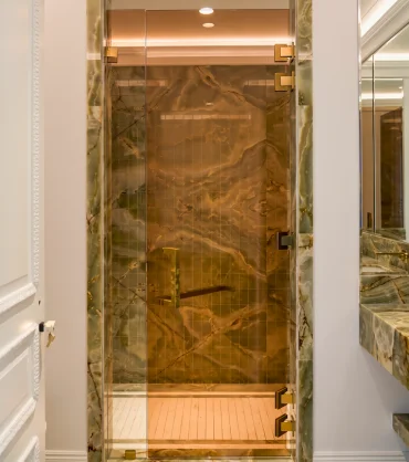 Glass partition installation in Dubai featuring a frameless shower enclosure by OBA